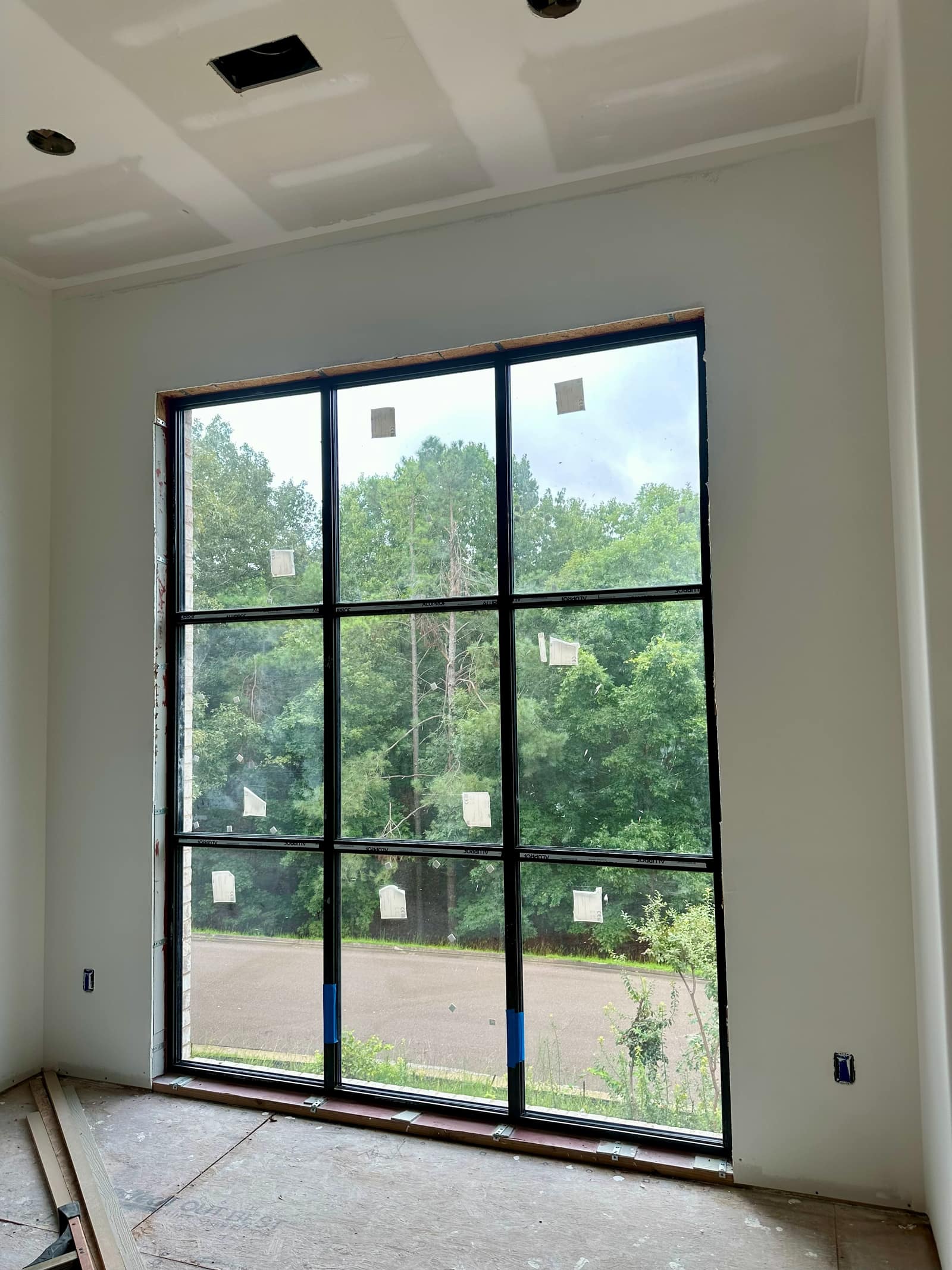 Living room picture window with muntin bars, set into the masonry opening.
