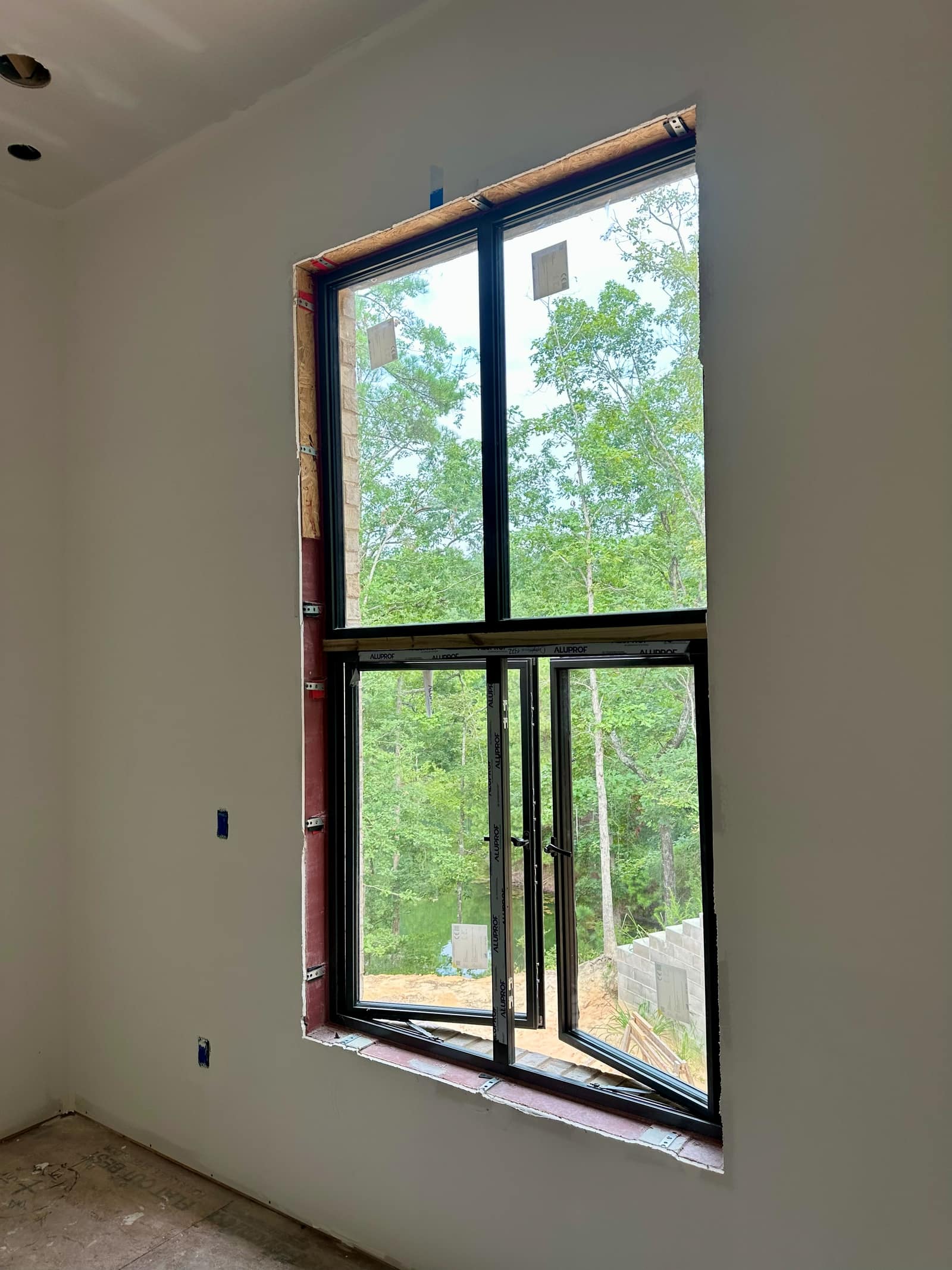 Fixed light stacked over a lower unit within a single structural opening.