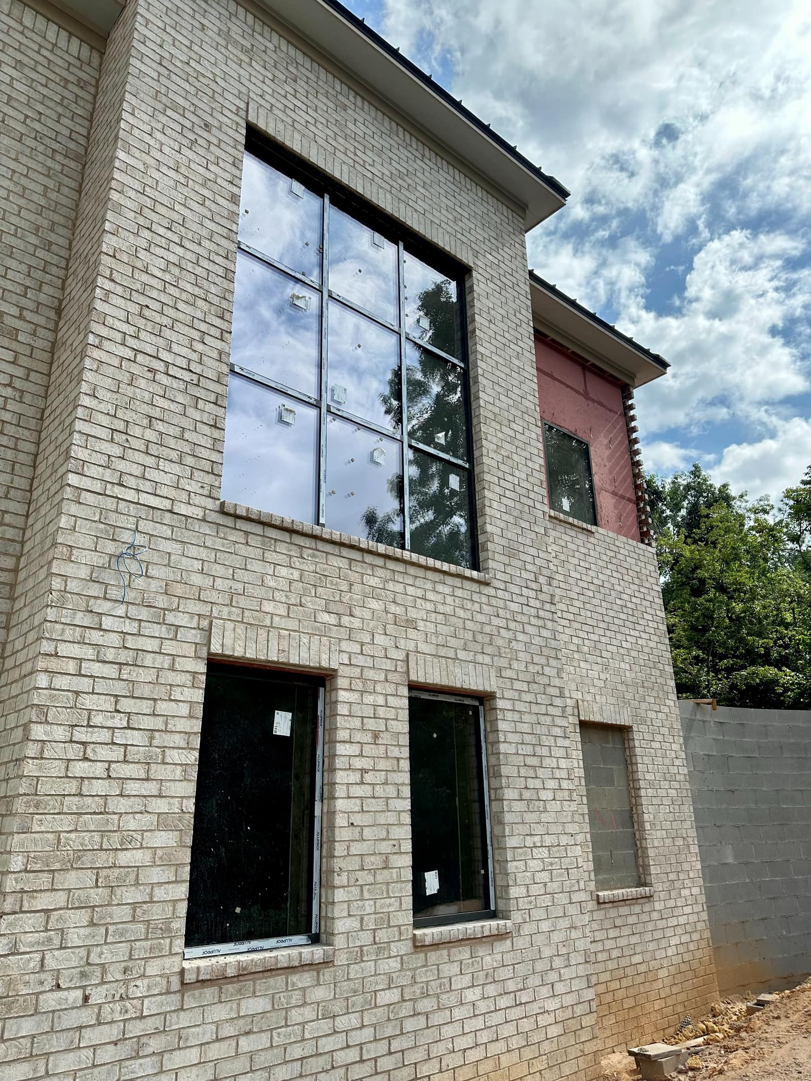 Brick facade with the upper grid window and ground-floor units in place.
