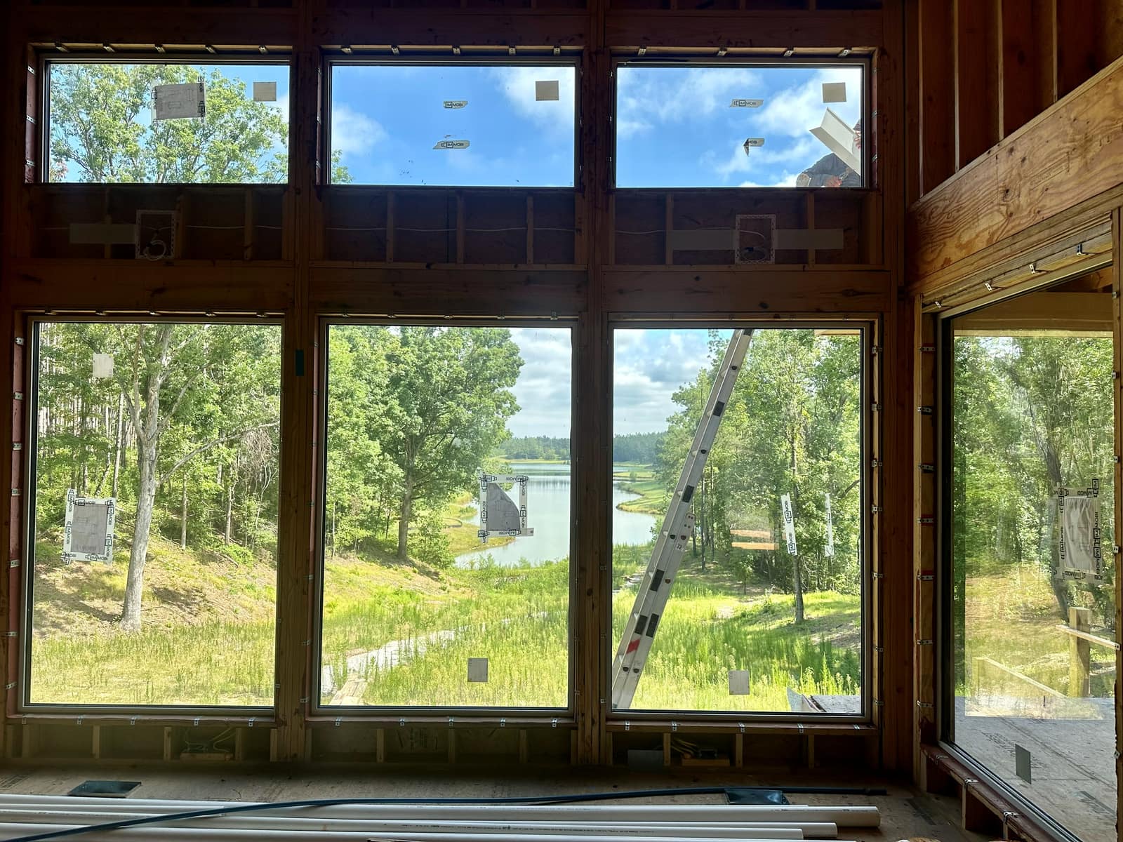 Main lake elevation from inside - fixed units under a full run of transom glazing.
