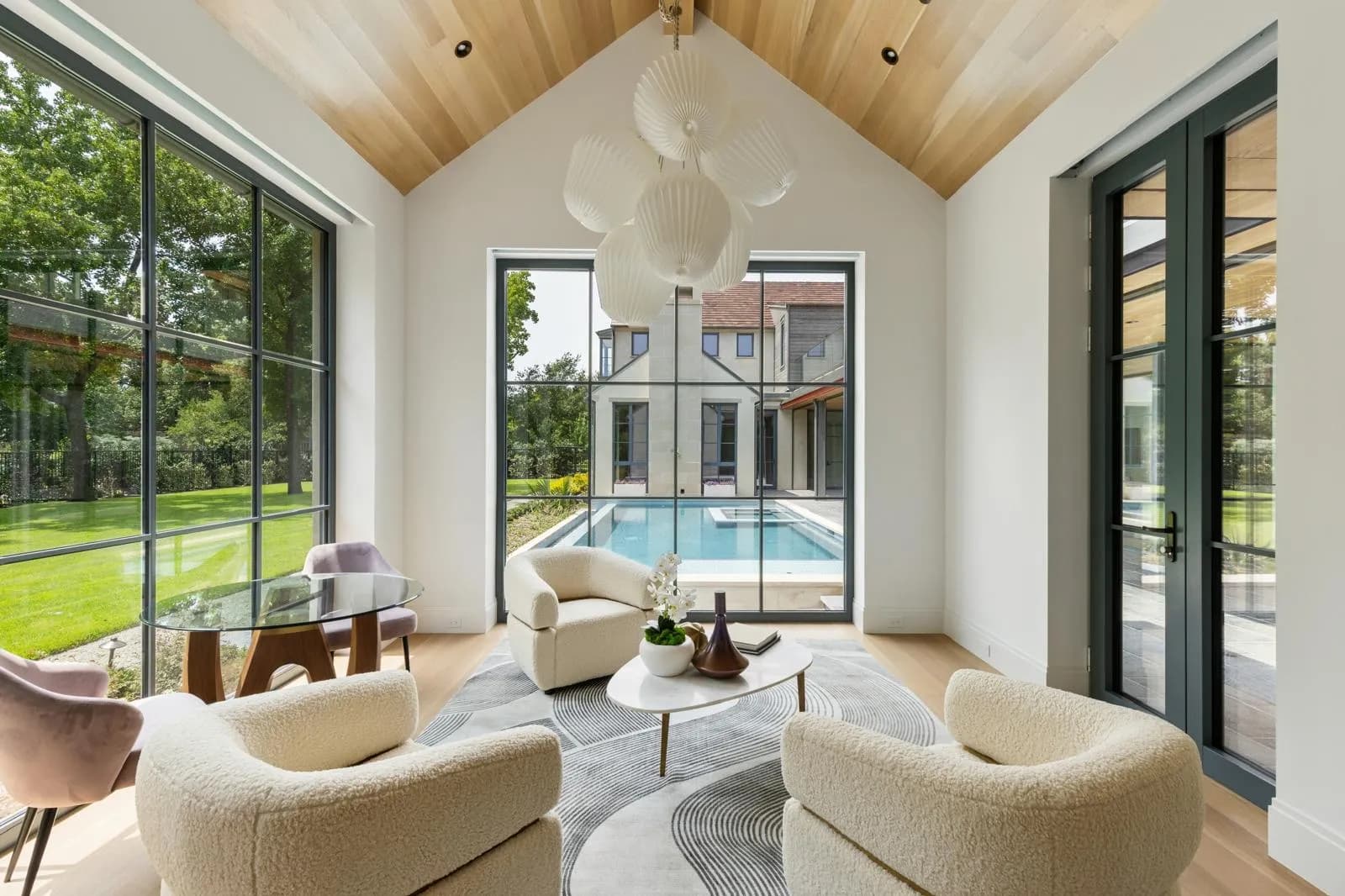Garden room with floor-to-ceiling Clad Hidden Sash windows with divided lites and French doors in a dark gray-green finish